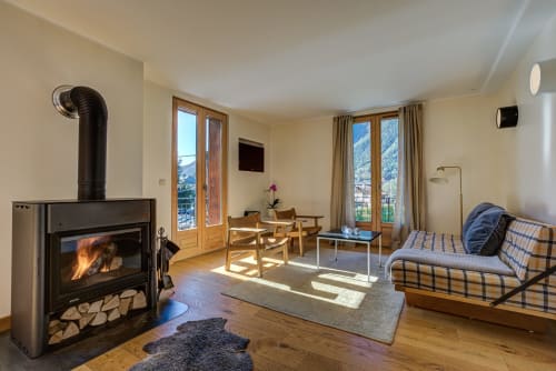 Living area with fireplace | Balcony Apartment – ​​Stunning View and Alpine Charm
