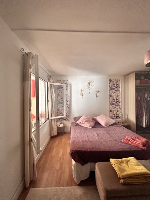 Chambre dans un appartement à Arles avec literie rose, parquet, fenêtre et décoration florale murale près du centre-ville