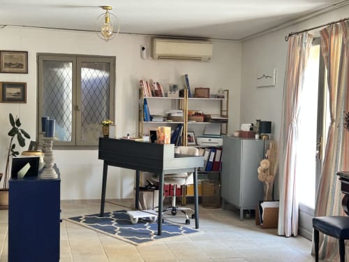 Bureau moderne dans un appartement d'Arles avec bureau, étagères et rideaux à rayures donnant sur le jardin