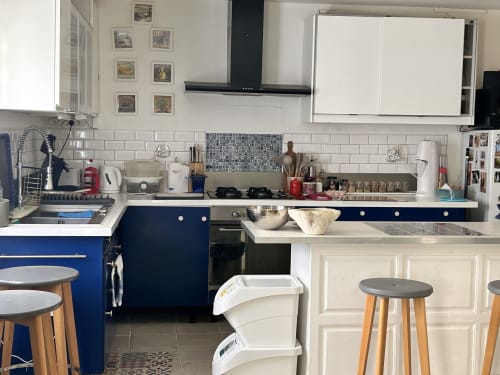 Cuisine moderne aux armoires bleues, carrelage métro blanc, électroménagers acier inoxydable et coin bar à Arles