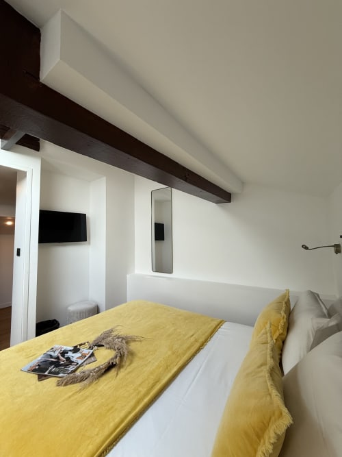 Camera Standard moderna al Boutique Hôtel Provencia Marseille con biancheria gialla, TV a muro e design minimalista bianco