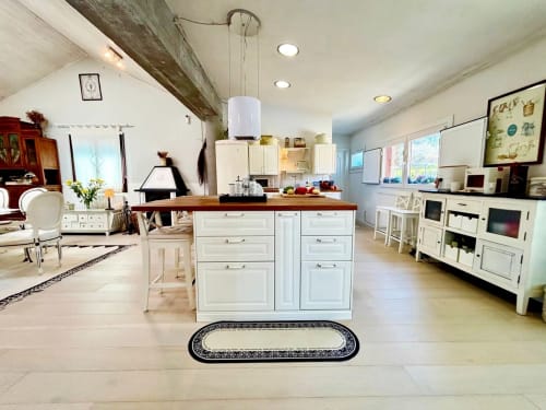 Cocina abierta integrada con comedor en Casa Celso, Baiona: muebles blancos, isla de madera y electrodomésticos modernos