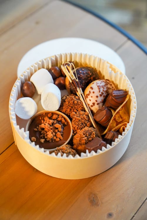 Assortiment de chocolats artisanaux en boîte blanche aux Cabanes et lodges du Belvédère, Serrières-sur-Ain