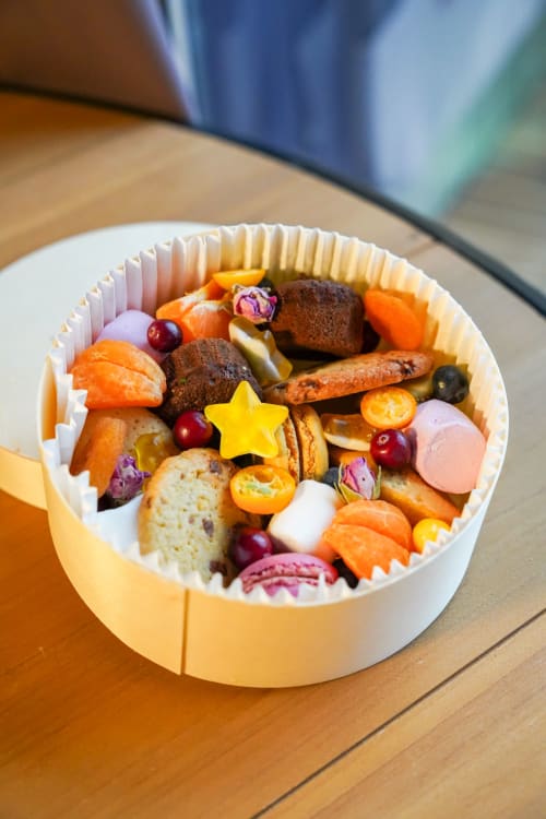 Plateau de charcuterie coloré avec pain, charcuteries, fruits et éléments décoratifs aux Cabanes et lodges du Belvédère