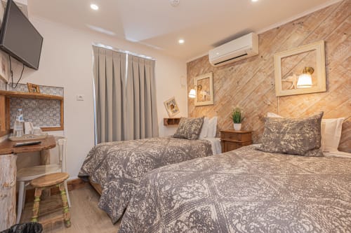 Standard room at Ninho Saloio hotel in Venda do Pinheiro with two beds, wooden accent wall, and modern amenities