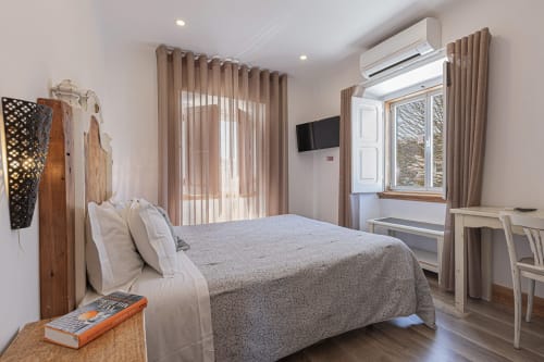 Premium bedroom at Ninho Saloio hotel in Venda do Pinheiro with bed, TV, desk, air conditioning, and wooden furnishings