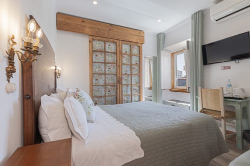 Premium bedroom at Ninho Saloio with wooden wardrobe, white bedding, TV, and modern amenities in Venda do Pinheiro