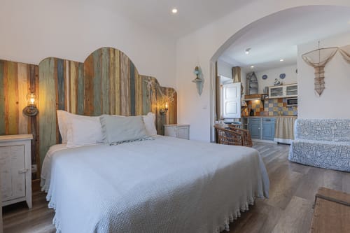 Seagull Studio at Ninho Saloio with driftwood bed, white linens, and rustic coastal decor