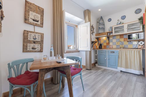 Seagull Studio at Ninho Saloio with dining table, blue chairs, kitchenette, nautical decor