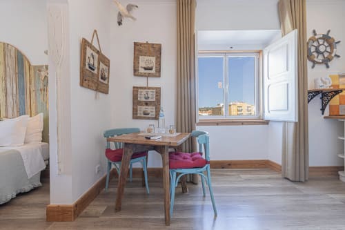 Seagull Studio with wooden table, blue chairs, nautical décor, and lake view at Ninho Saloio in Venda do Pinheiro