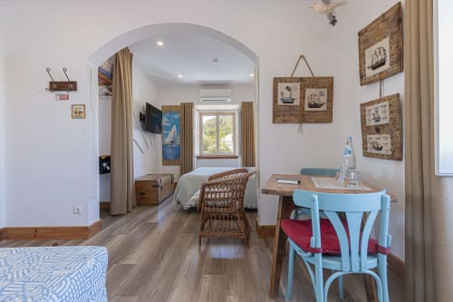 Seagull Studio at Ninho Saloio with nautical decor, wooden floors, TV, work desk, and lake view in Venda do Pinheiro