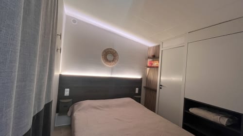 Chambre moderne à la villa Le Maquis Plage avec lit queen-size, tête de lit noire, éclairage LED et climatisation à Poggio-Mezzana