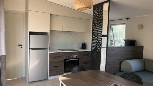 Cuisine et salle à manger modernes de la villa Mobil-Home l'Arbousier à Le Maquis Plage, Corse, équipées d'appareils en acier inoxydable