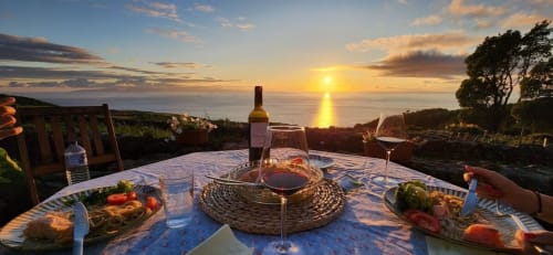 Outside view with sunset and sea while eating with wine | Delight in the Charm of Ti Chôa - Casa do Biscoitinho