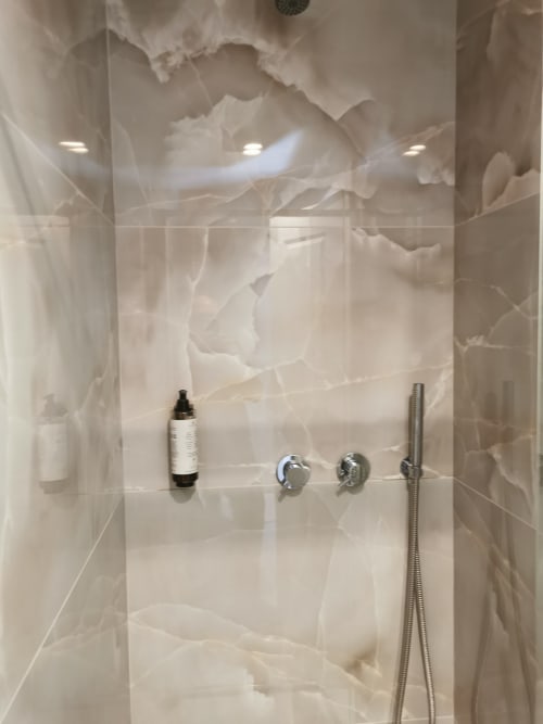 Bagno moderno nella suite deluxe dell'Hotel Fiori Rome con rivestimenti effetto marmo, soffione pioggia e rubinetteria cromata
