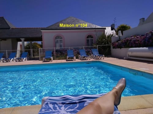Piscine de la Maison n°104 à Locations Loc'Maria, Belle Île en Mer avec transats et bâtiment rose