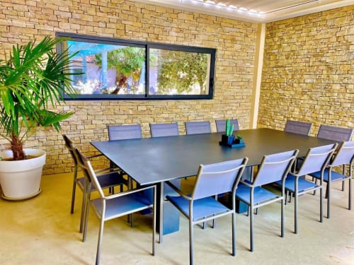 Modern conference room at La Maison D'ambrine BnB in Chamaret with brick walls, large table, and natural light