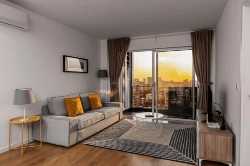 Área de Estar com Vista para a Cidade | Apartamento Aconchegante e Confortável de Um Quarto para a Sua Estadia Perfeita