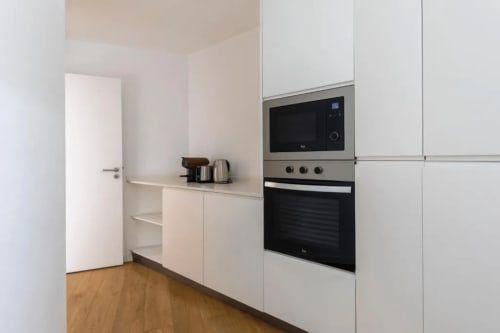 Cozinha com Eletrodomésticos | Apartamento Aconchegante e Confortável de Um Quarto para a Sua Estadia Perfeita