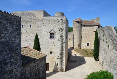 Medieval stone castle courtyard at La Maison D'ambrine, Chamaret with towers and ivy-covered walls