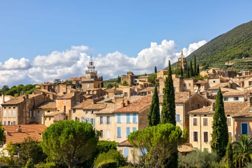 Le charmant village médiéval de Chamaret en France avec ses bâtiments en pierre, ses cyprès et son clocher sous un ciel bleu