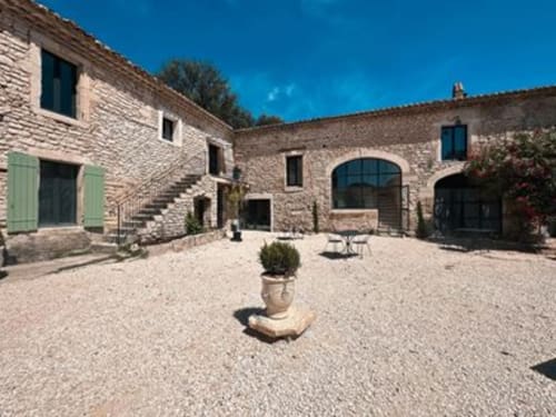 Binnenplaats van La Maison D'ambrine in Chamaret met stenen gebouwen en terracotta pot