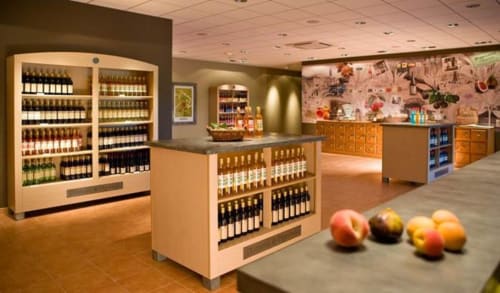 La Maison D'ambrine wine tasting room with bottles displayed and fresh fruit on counter