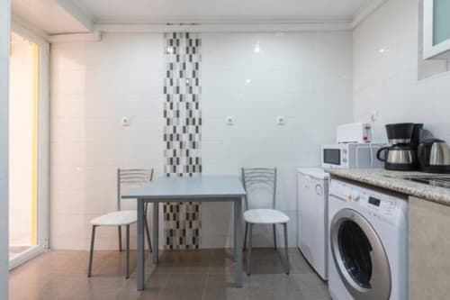 Kitchen with washing machine and dining area | Modern Comfort in the Bustling City Center