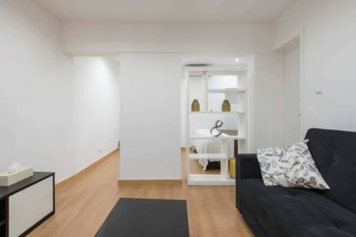 Living area with sofa and pillows | Modern Comfort in the Bustling City Center