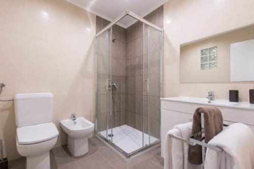 Bathroom with sink, toilet, and shower area | Modern Comfort in the Bustling City Center