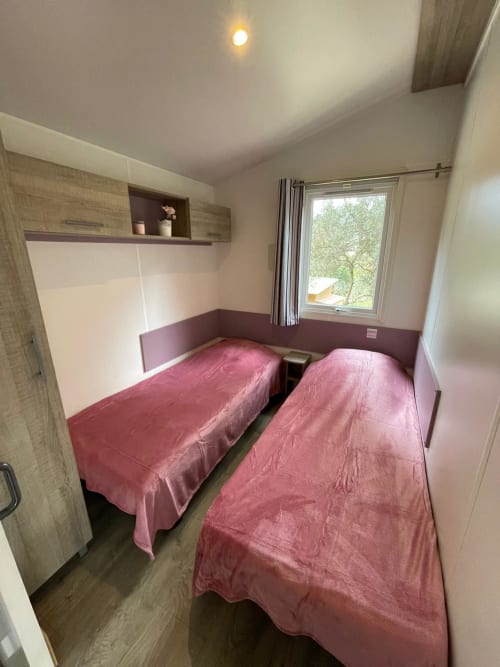 Chambre twin avec literie rose à Camping La Lézardière, vue montagne, équipements modernes