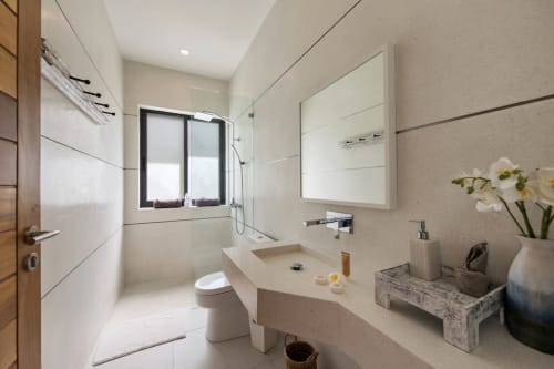 Bathroom with sink, shower area, and toilet with amenities | Experience Breathtaking Sea Views at Villa Indigo
