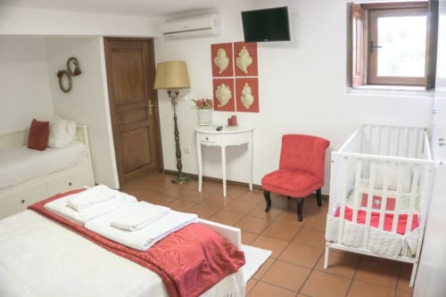 Room with bed, sofa bed, and a crib for guest with babies | Casa da Pedrosa: Your Ideal Retreat in Ponte de Lima, Portugal