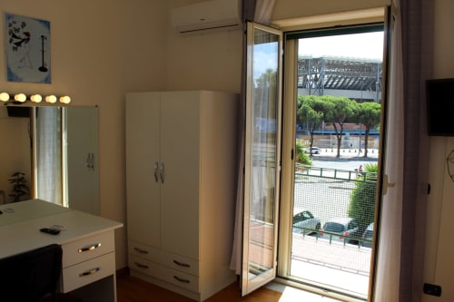Modern bedroom at Blackwoody Contemporary Hospitality in Naples with white wardrobes, vanity mirror, and balcony overlooking