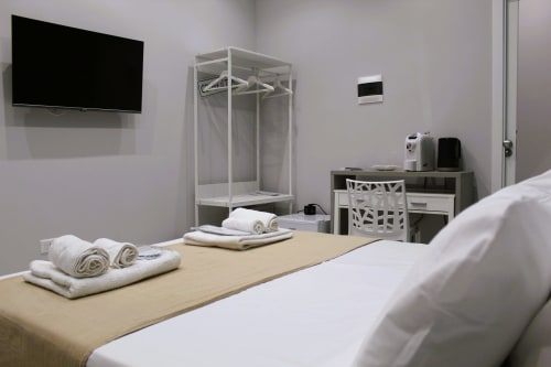Modern bedroom at Blackwoody Contemporary Hospitality in Napoli with bed, TV, wardrobe, and welcome amenities