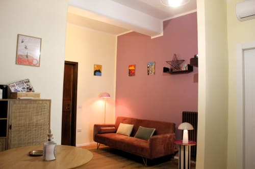 Modern Naples BnB living room with coral accent wall, rust sofa, and contemporary furnishings at Blackwoody