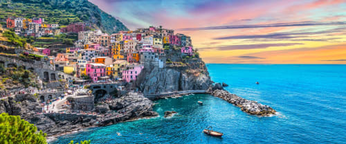 Suggestivo villaggio arroccato su scogliera con edifici dai colori pastello affacciati sulle acque turchesi del Mediterraneo vicino a Genova, Italia