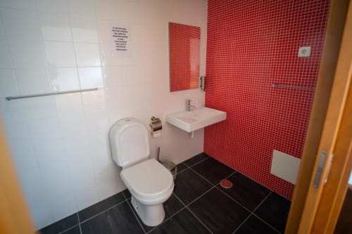 Bathroom with toilet, mirror, and sink | Welcome to Casa Rural "A Escola" – Your Tranquil Retreat in Pampilhosa da Serra