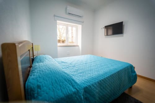 Comfortable bedroom with television and air condition | Welcome to Casa Rural "A Escola" – Your Tranquil Retreat in Pampilhosa da Serra