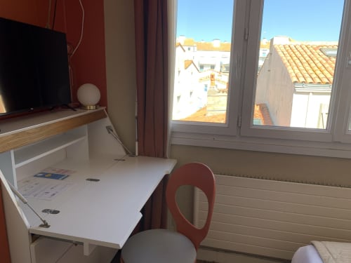 Single room with desk, TV, and city view at Hôtel Maison Richet in Les Sables-d'Olonne
