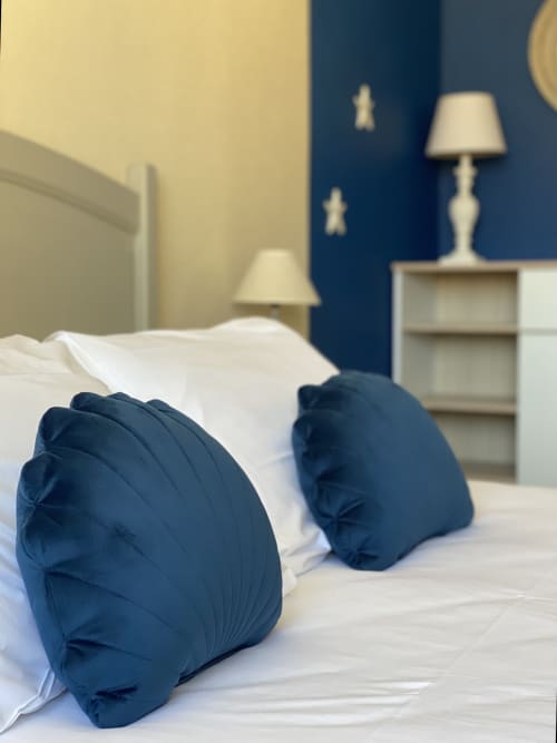 Luxury suite bedroom at Hôtel Maison Richet with navy pillows, white linens, and bedside lamp