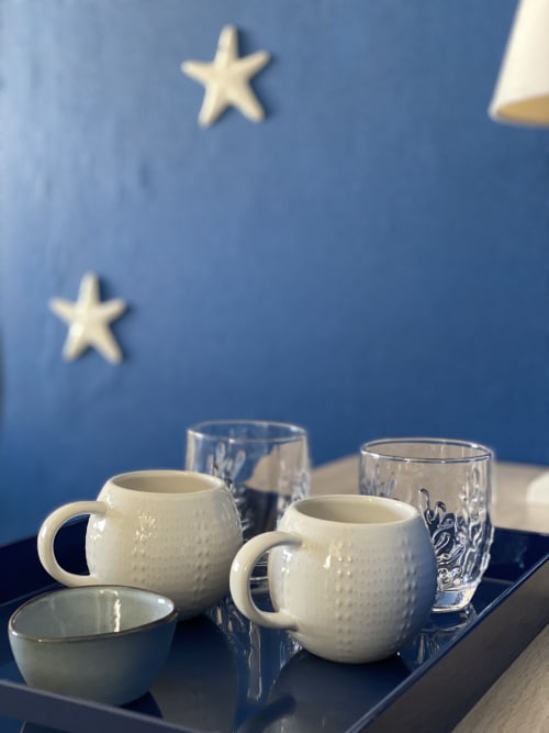 Elegant welcome setup at Hôtel Maison Richet with cream pitchers and glasses against blue wall with stars