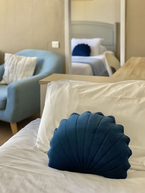 Modern bedroom at Hôtel Maison Richet in Les Sables-d'Olonne with navy decorative pillow and blue armchair