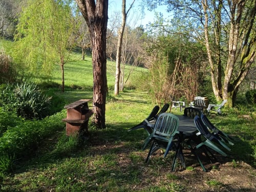 Espace extérieur privée, avec coin barbecue et salon de jardin à l'ombre des arbres