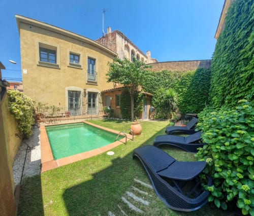 Backyard pool and lounge area at Finques Garcia Enrich hotel in Palafrugell, Spain