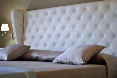 Letto di lusso con testiera bianca trapuntata e cuscini a Villa Blanche Holidays, Marsala