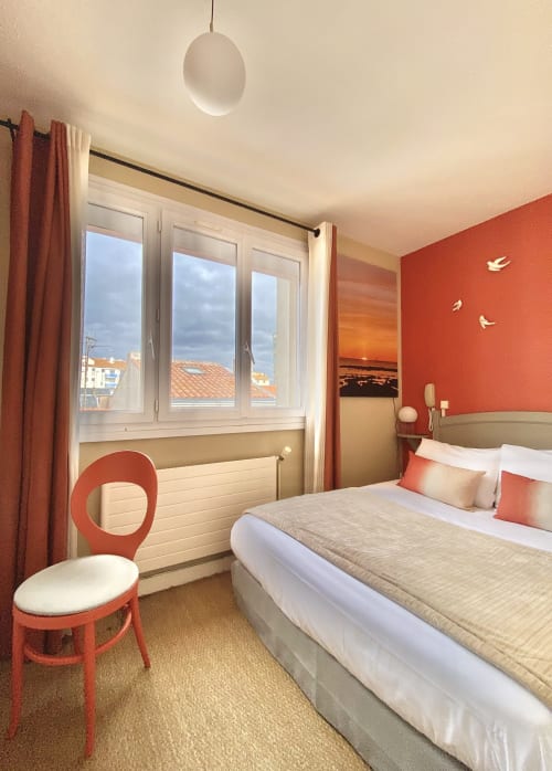 Modern single room at Hôtel Maison Richet with red accent wall, city views, and contemporary furnishings in Les