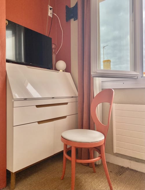 Modern single room at Hôtel Maison Richet with workspace, flat-screen TV, coral chair, and city views in Les Sables-d'Olonne
