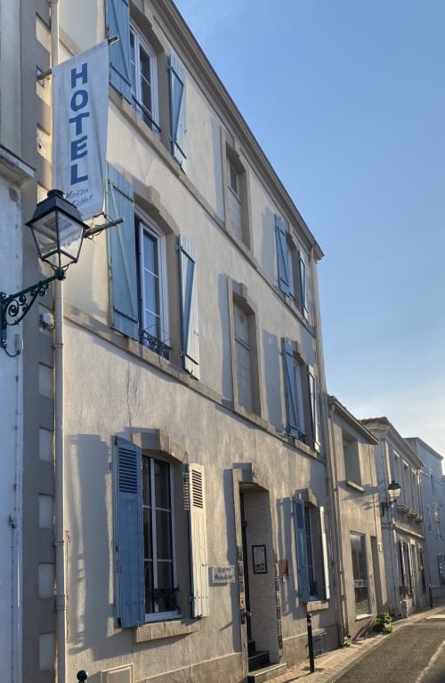 Hôtel Maison Richet facade in Les Sables-d'Olonne with blue shutters and hotel sign