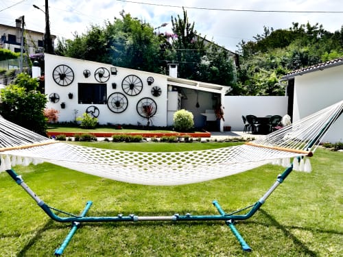 Cabaña blanca con relojes decorativos en Casa Caeiro, Baiona, con hamacas y zona de jardín para descansar